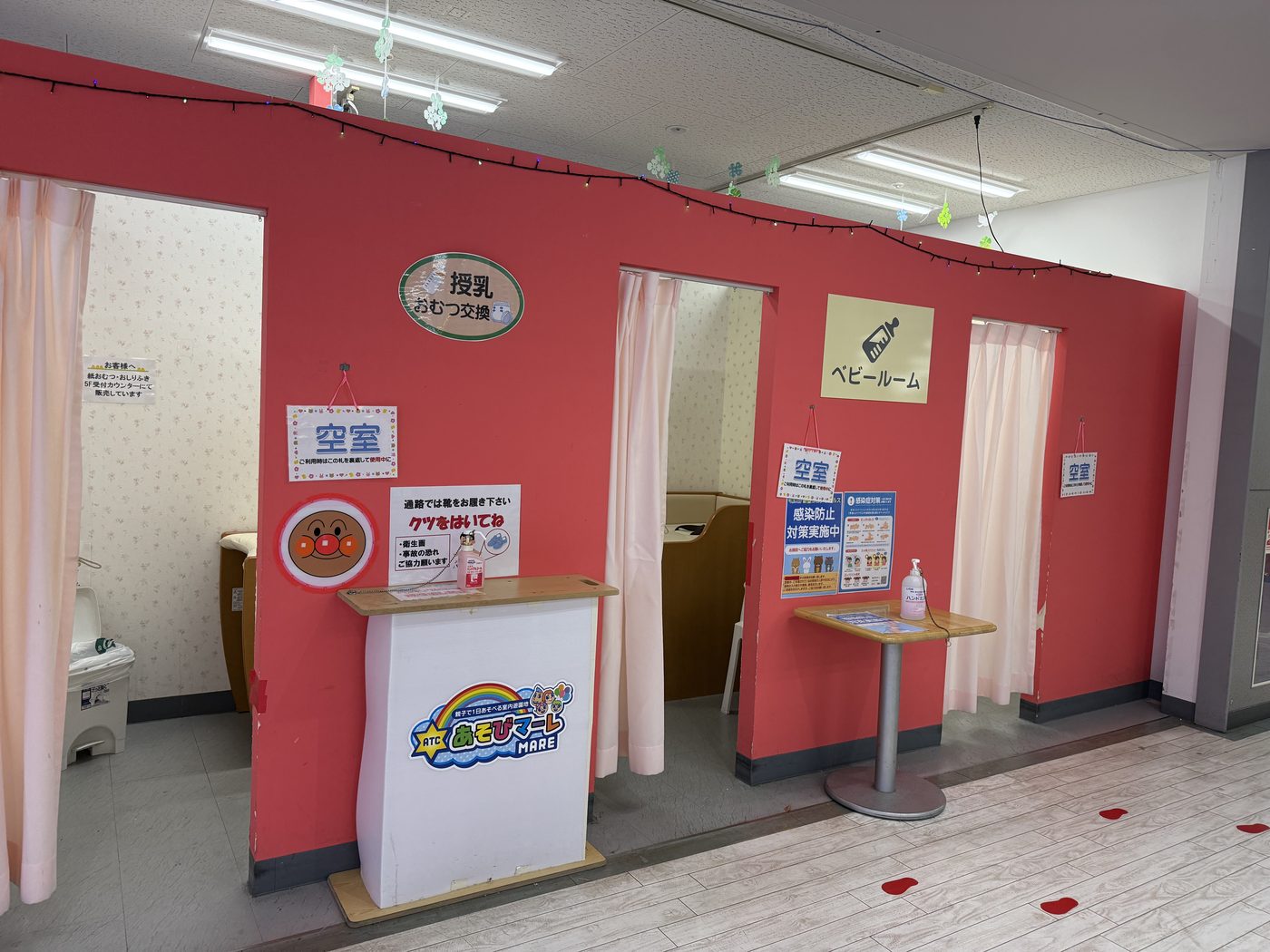 「授乳・おむつ交換」「ベビールーム」の看板が並んだ赤い壁