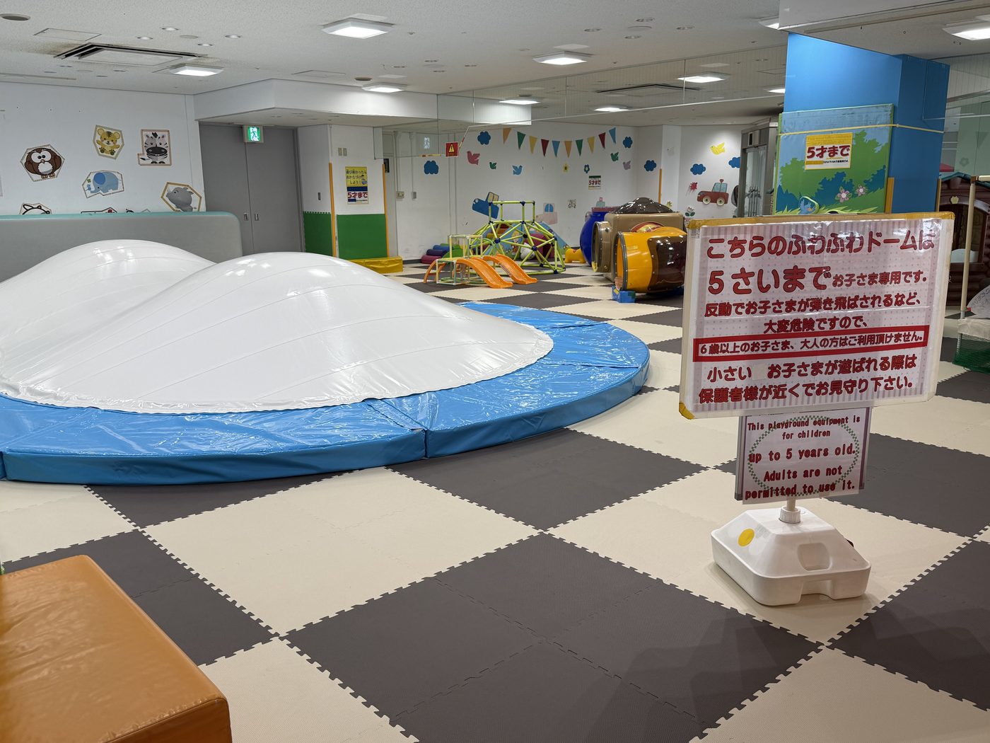 「5さいまで」と書かれた看板の横にある白いふわふわドーム
