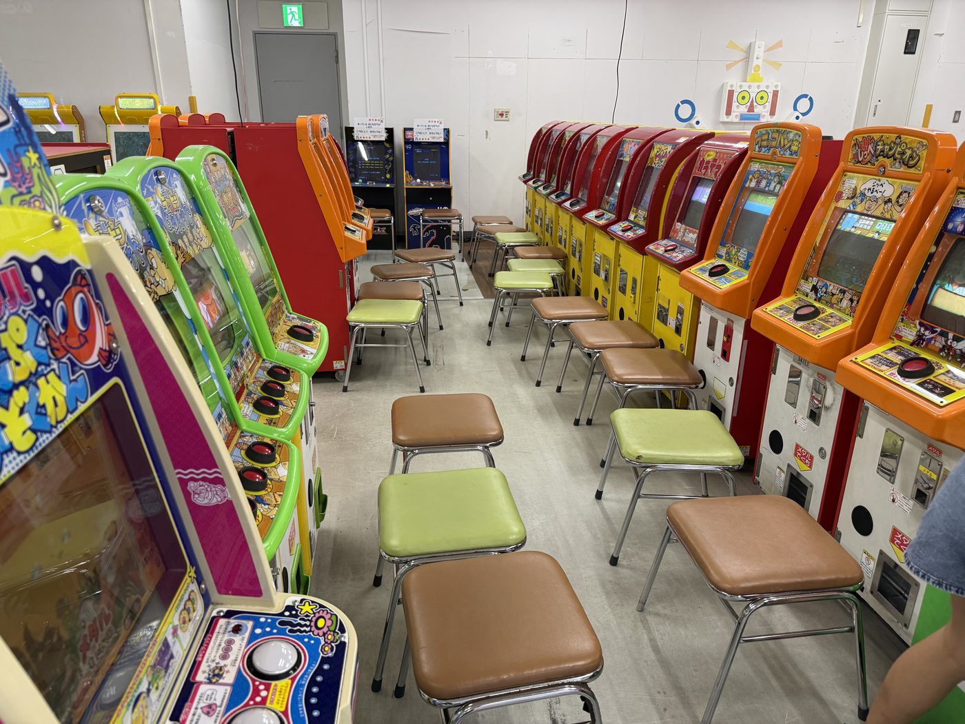 アーケードゲーム機と椅子がずらりと並んだメダルコーナー