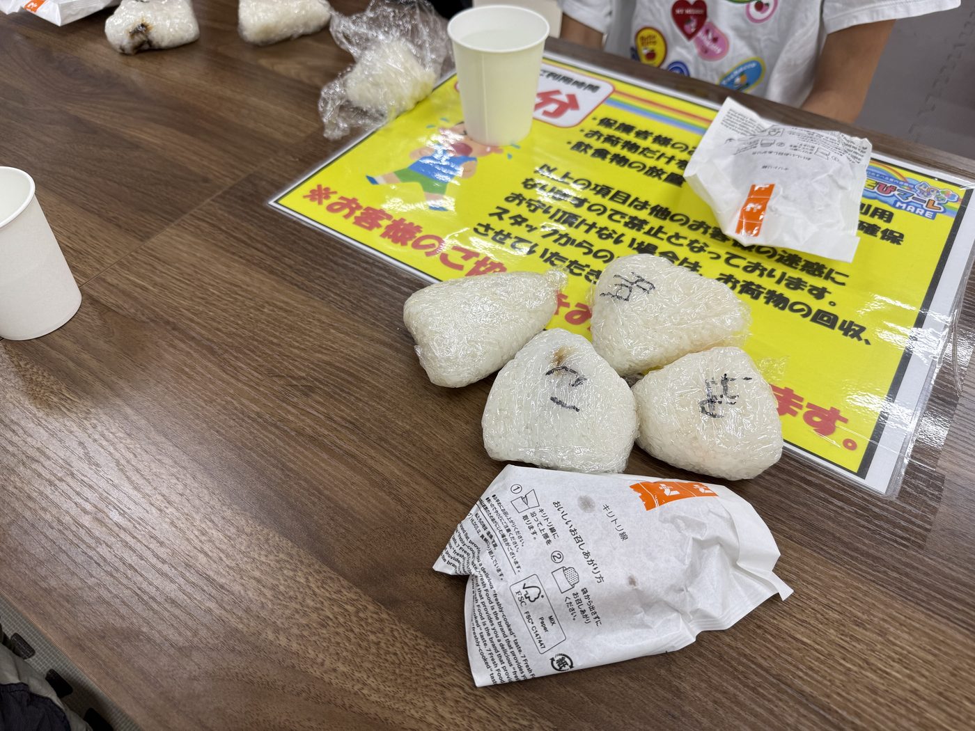 ラップに包まれた手作りおにぎりが4つテーブルに並んでいる