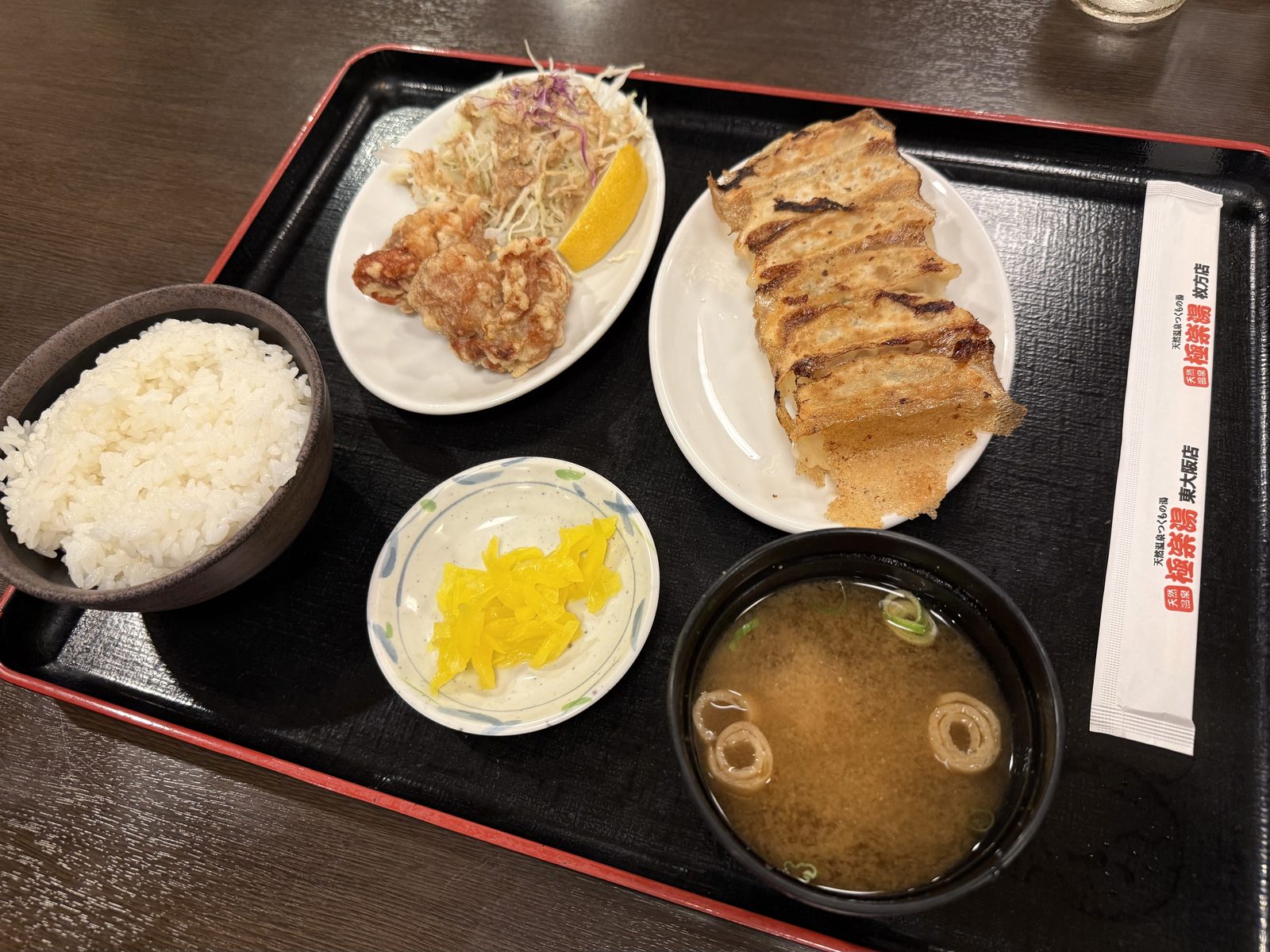 こんがり焼けた餃子、唐揚げ、ごはん、味噌汁がのった焼き餃子定食