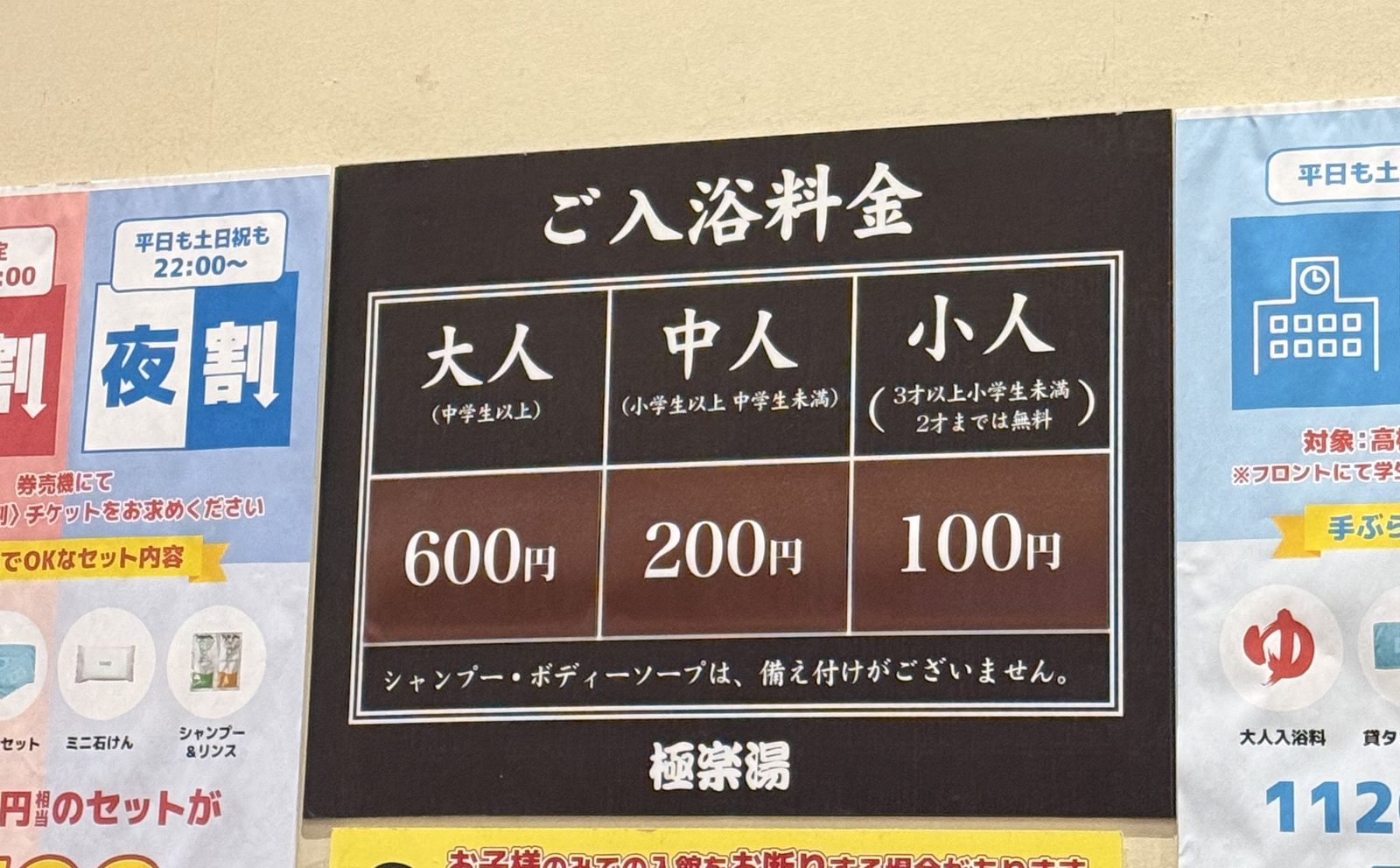 券売機の上に貼られた「ご入浴料金」の看板。大人600円・中人200円・小人100円と書かれている