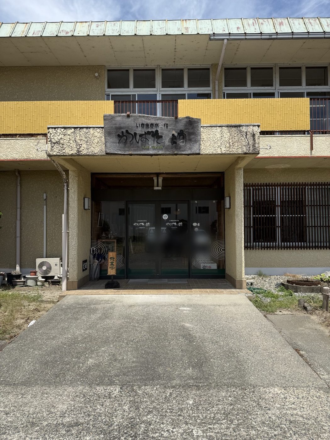 木の看板に「いき生き水文化 かばた館」と書かれた玄関