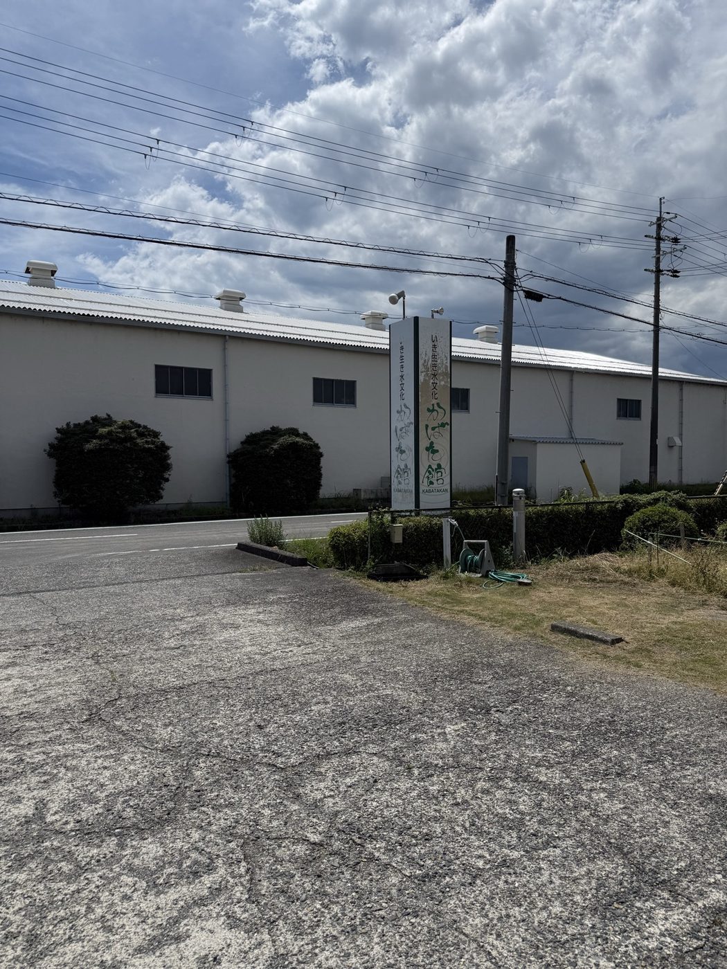 道路沿いに立つ「かばた館」の縦看板と白い建物