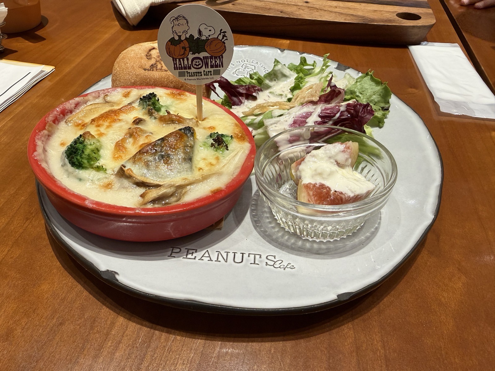 カボチャのグラタン、グリーンサラダ、いちじくとチーズのデリ、スヌーピーの焼印が入ったパンが並んだハロウィーン限定のワンプレート
