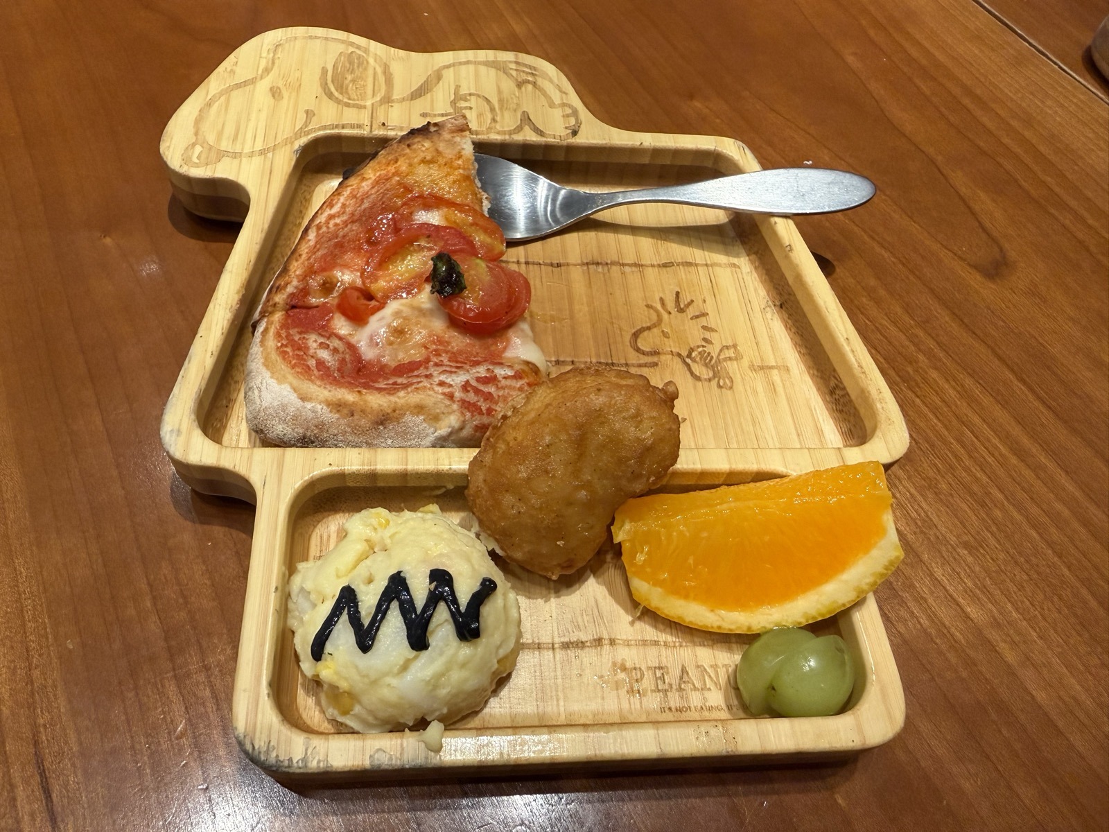 キッズプレートのポテトサラダ。チャーリー・ブラウンのシャツのギザギザ模様がソースで描かれている